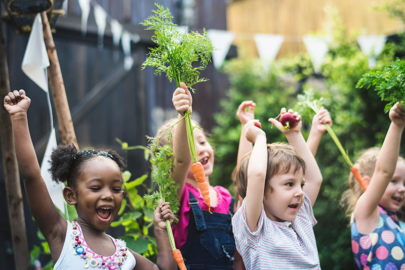 Young children Holding Up Carrots