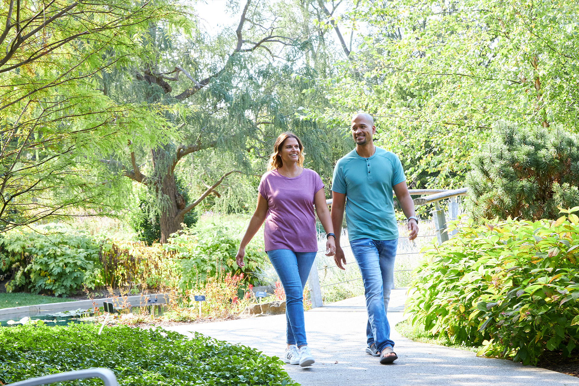 couple walking through Rock Garden in summer, lush greenery surrounding them